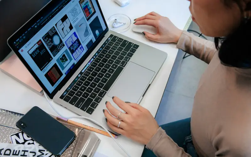 A designer reviewing a website layout on a laptop